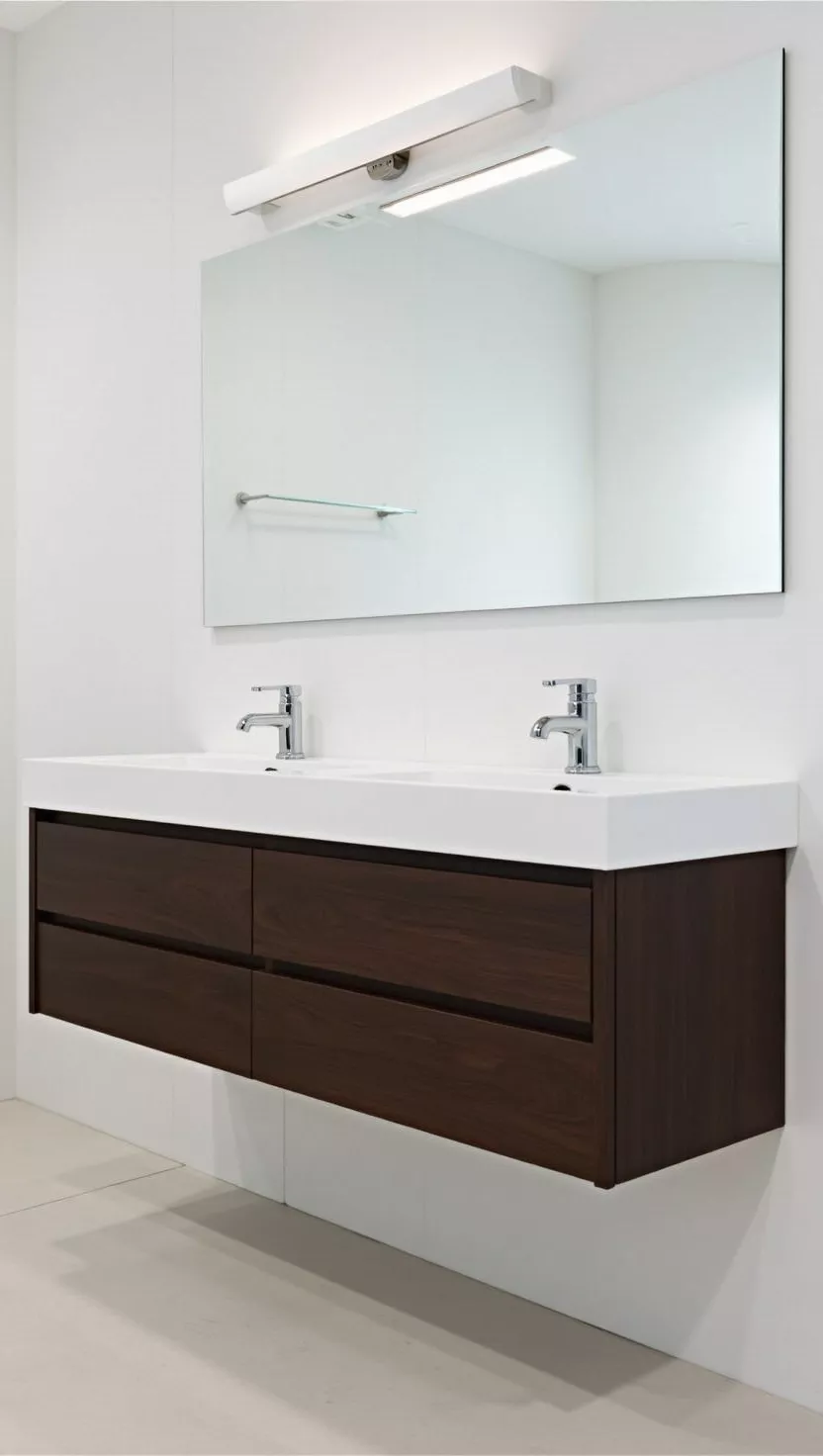 Moderner Waschtisch A modern bathroom, floating dark wood vanity with integrated double sinks, sleek chrome faucets, large frameless mirror, minimalistic and functional.