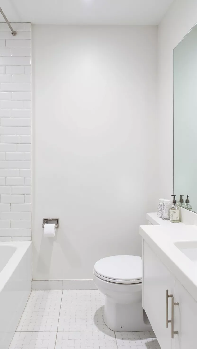 Ganz in Weiß A modern bathroom, entirely white minimalist design, white tiles, white vanity, white fixtures, creating a bright and airy space.